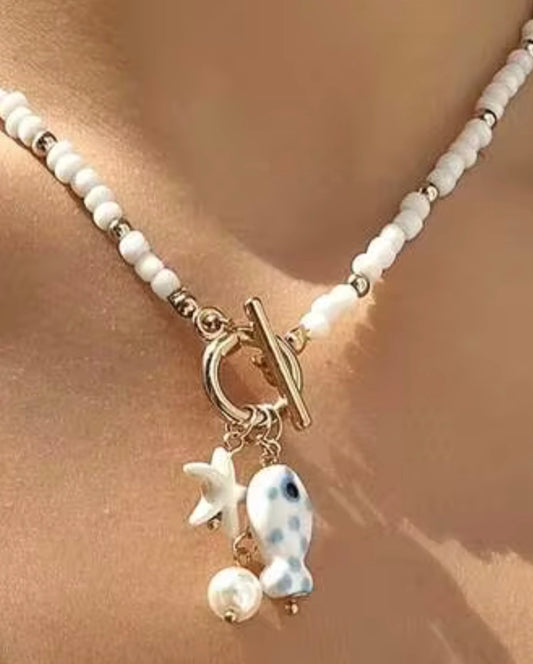 White & Gold Ceramic Beaded Toggle Necklace with White & Blue Fish, Star and Pearl pendants.